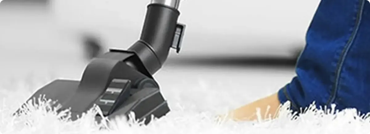 Close-up of a professional vacuuming a white carpet in Barksdale Afb.